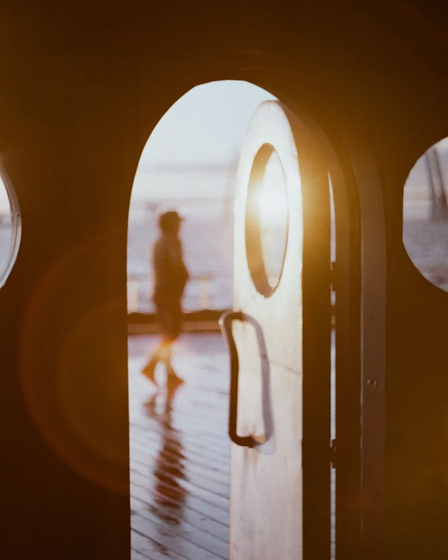 Une silhouette qui franchit une porte vers la lumière; image d'ambiance