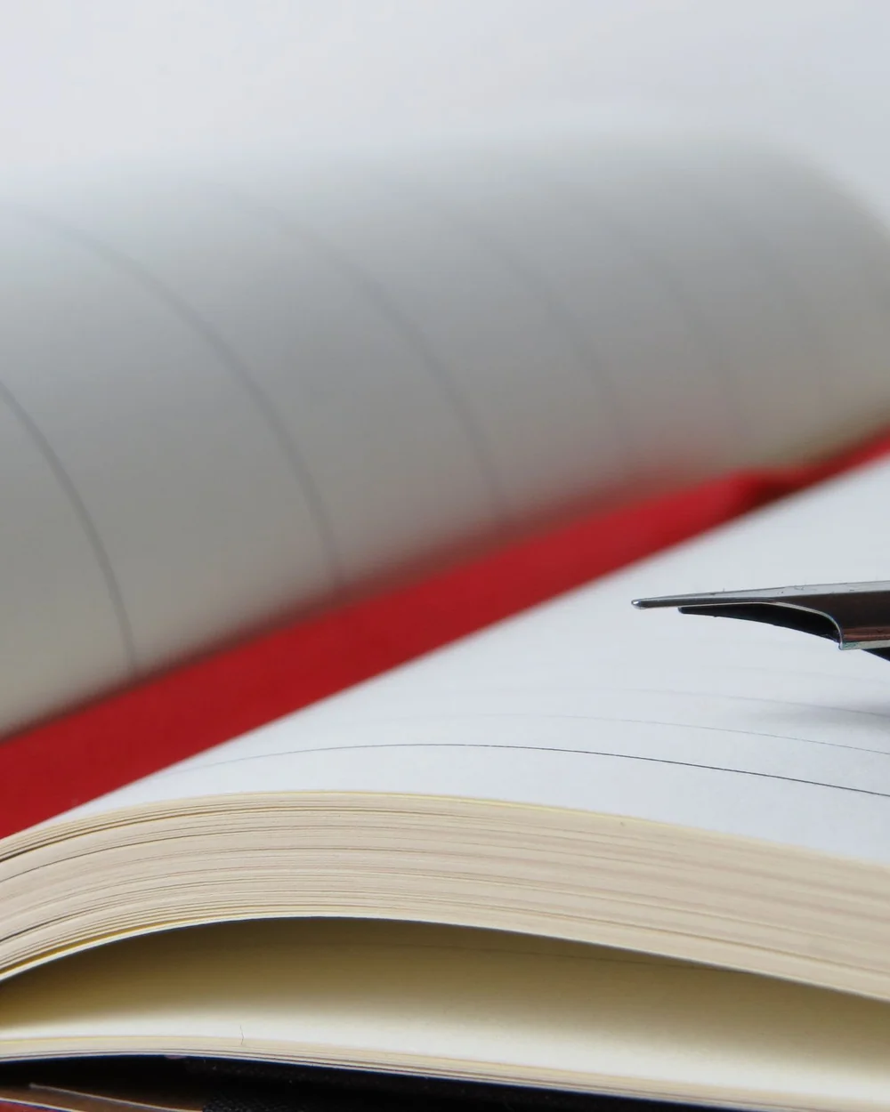 Un carnet ouvert au signet rouge et un stylo; image d'ambiance