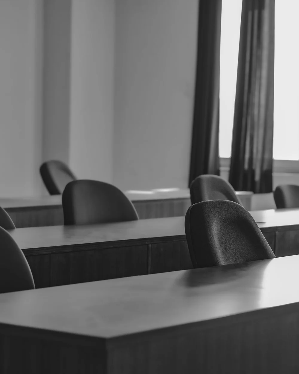 Une salle de formation vide, tables de bois et fenêtre; image d'ambiance